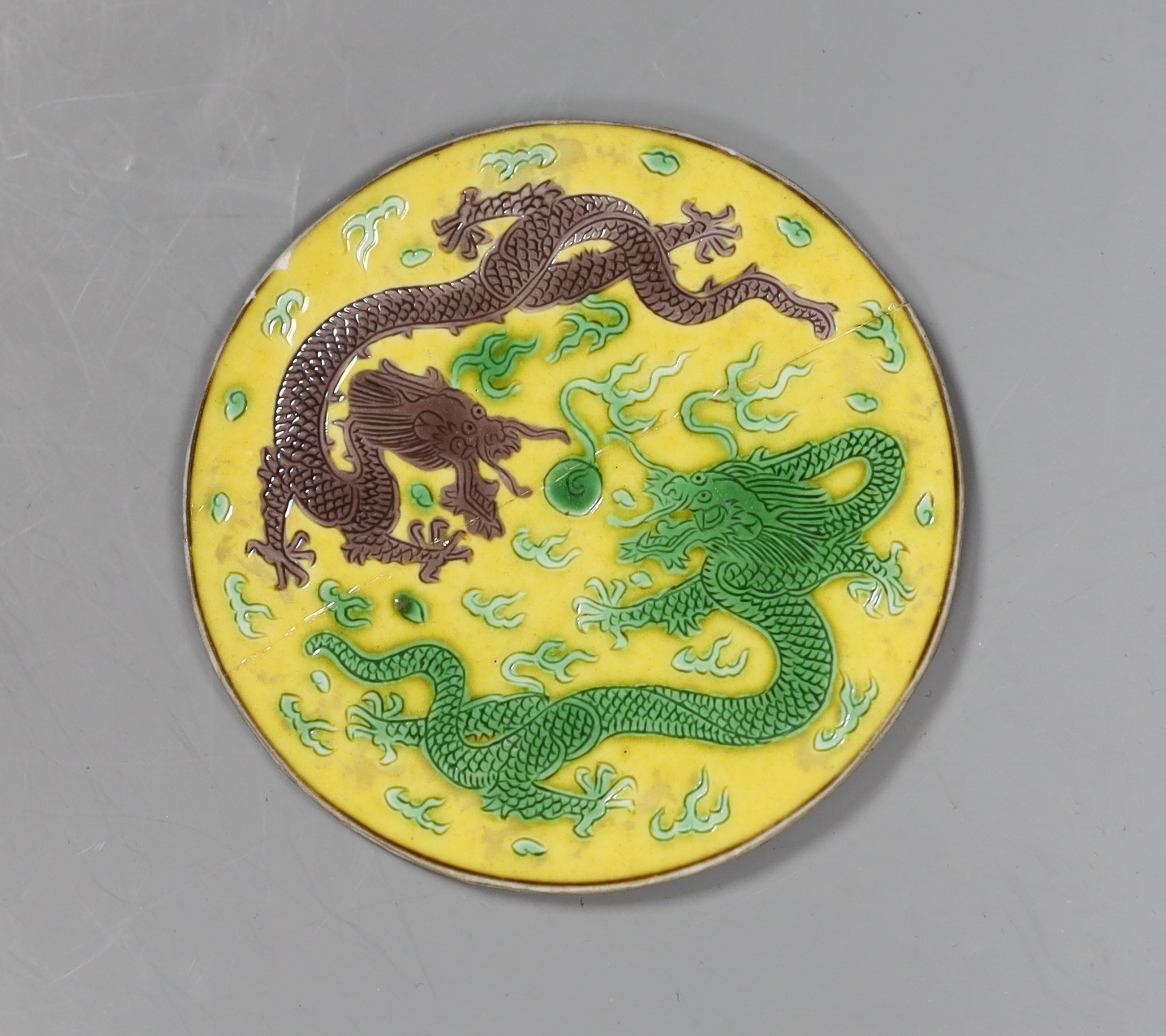 A Chinese sancai porcelain ‘dragon’ roundel, cut from the centre of a dish, Daoguang mark and period, 9cm diameter